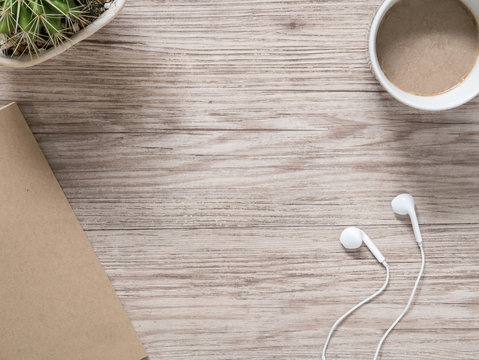 earphones,notebook and coffee on wooden background