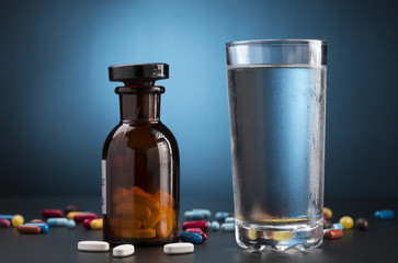 Medicine pills bottle and glass of drink water