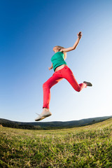 Happy girl jumping in nature, image shot with fish-eye lens