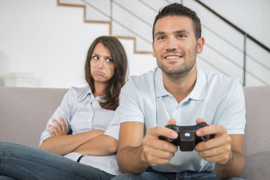 Bored girlfriend and her man playing video games