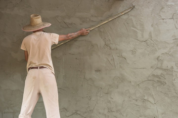 Builder worker plastering  concrete at wall