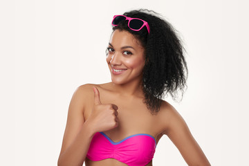 Smiling woman in swimsuit gesturing thumb up