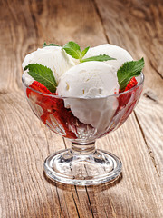 Ice cream with strawberries on an old table