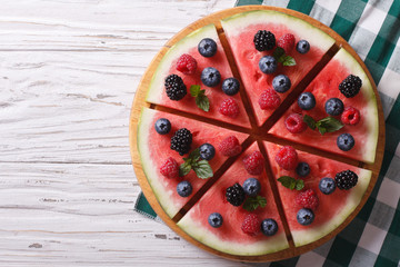 Watermelon decorated with berries horizontal top view
