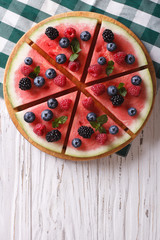 Watermelon decorated with berries vertical top view

