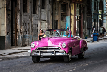 Kuba pinker amerikanischer Oldtimer fährt auf der Strasse in Havanna Stadt