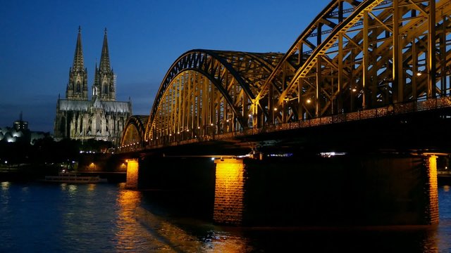 Gothic Cathedral and iron bridge across Rhine river after sunset. Cologne, Germany