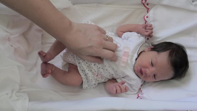 a newborn baby girl and his mum's hand