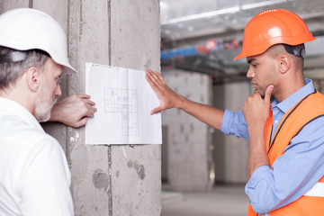 Cheerful skilled builders are solving construction problems