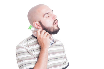 Man cooling his neck with cold water in plastic bottle