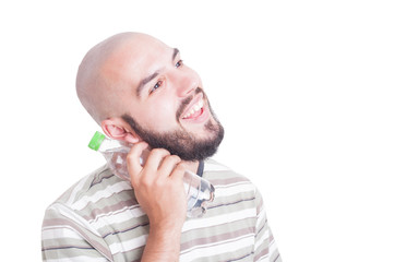 Smiling man cooling neck with cold water in plastic bottle