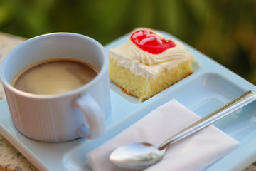 Coffe with small fancy cakes