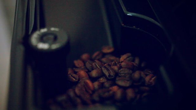 putting some coffee beans in the coffee machine