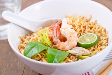 Hot and spicy instant noodle on the wood table.