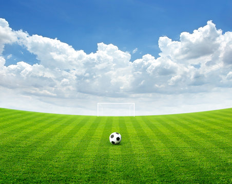 Soccer ball on the green field, Blue sky with cloud in summer