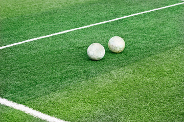 Green grass field with white mark line and two old football soccer