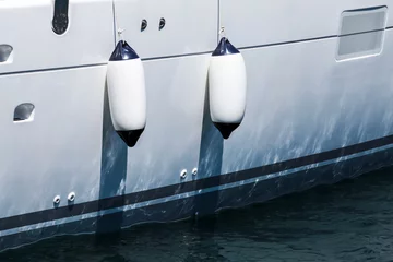 Deurstickers Small ship fenders hanging above white yacht hull © evannovostro