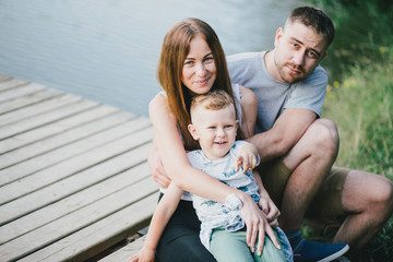 Fototapeta premium Beautiful happy family having picnic near lake