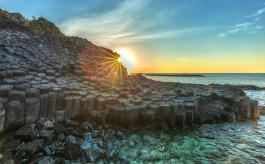Obraz premium Sunstar on Ganh Da Dia, Vietnam higher as the sun light gauze after Giants Causeway ice sheet gives beauty of this beautiful volcanic rock at sunrise