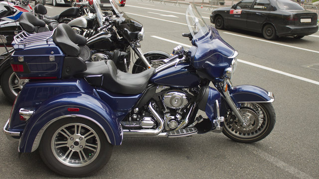 Dark blue three-wheeled bike with shiny chrome accents