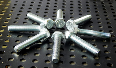 Metal art. Flowers from bolts on black iron background