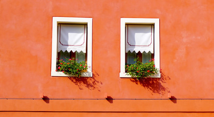 two windows with orange wall