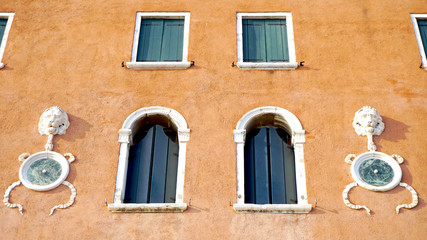 Fototapeta na wymiar Windows on orange brown wall building