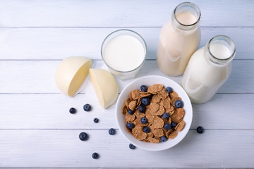 Top view on a breakfast with cornflakes blueberries and fresh dairy.