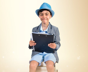 Cute boy sitting on books