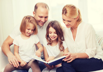 smiling family and two little girls with book
