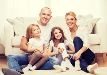 parents and two girls sitting on floor at home