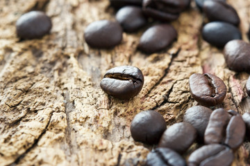 Fototapeta na wymiar coffee beans on the old wooden background, warm tone and soft focus