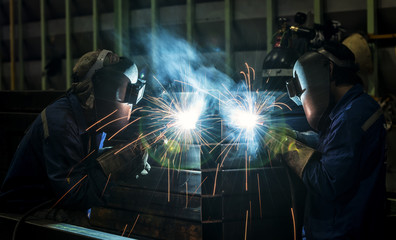 Worker with protective mask welding metal