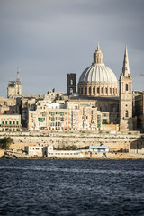 Fototapeta na wymiar Valletta, Malta. A view over Marsamxett harbor of the skyline of the Maltese capital dominated by the dome of St. Paul's Anglican Cathedral.