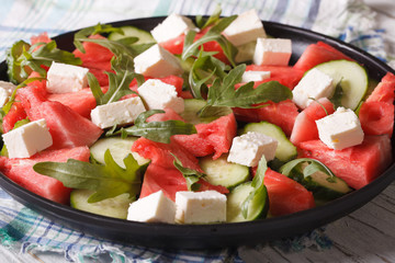Watermelon salad with feta cheese, arugula and cucumber closeup 
