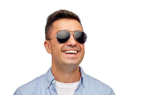 face of smiling man in shirt and sunglasses
