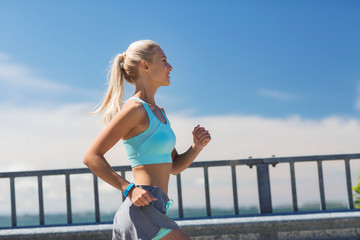 smiling young woman running outdoors