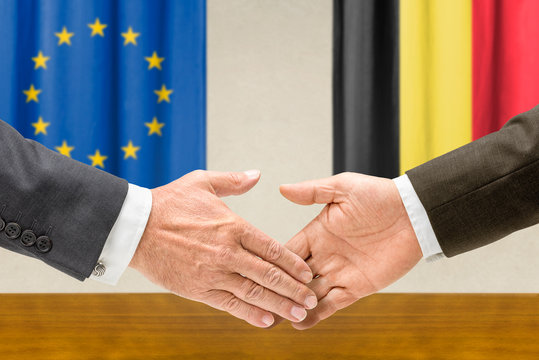 Vertreter der EU und Belgiens reichen sich die Hand