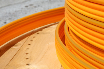 coils of orange plastic pipes for the installation of undergroun