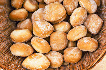 Wheat white breackfast bread rolls in a rustic braided basket