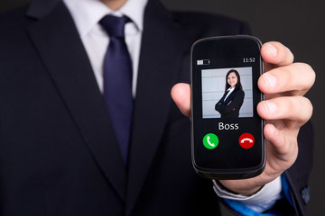 hand holding smart phone with incoming boss call