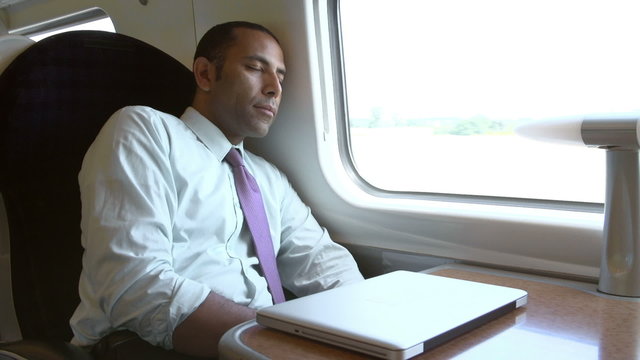 Businessman Resting On Train Journey
