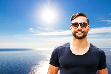 Sportlicher Mann mit Sonnenbrille am Meer