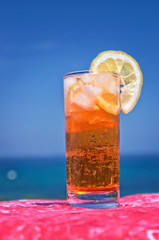 Cocktail drink in front of summer sea and sky background