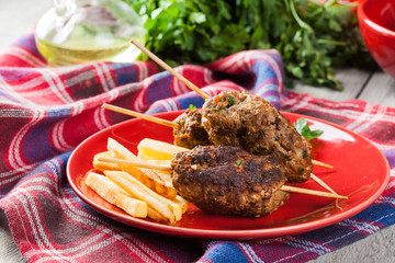 Barbecued kofta with fries on a plate