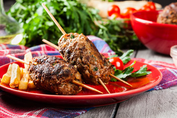 Barbecued kofta with fries on a plate