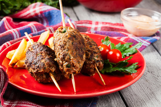 Barbecued kofta with fries on a plate