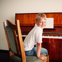 little happy boy plays piano