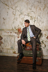 Businessman sitting on suitcases. Business trip.