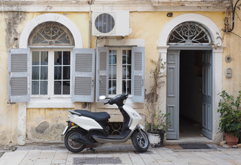 Naklejka na ściany i meble Motor Scooter Parked Outside Typical European Building